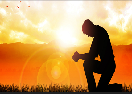 A man kneeling down in front of the sun.