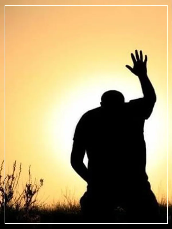 A person standing in the sun with their hand up.