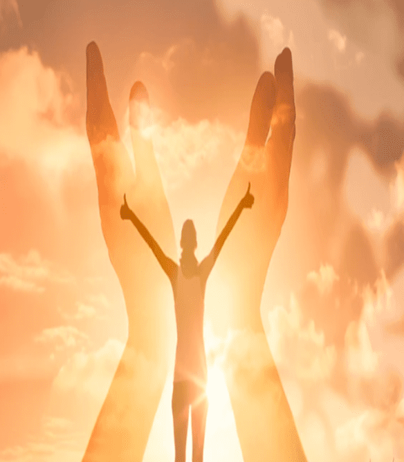 A person standing in front of two hands with the sun shining on them.